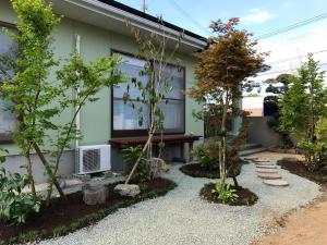 a garden with trees in front of a house at Yuuwa Guesthouse in Mifune
