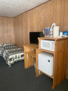 a room with a desk with a microwave and a bed at Tolsona Lake Lodge in Glennallen