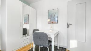 Habitación blanca con mesa y 2 sillas en HOMEY Coloc goodLife - Colocation moderne - Chambres privées - Wifi et Netflix - Au pied du tram pour Genève en Ambilly