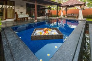 a pool with a table in the middle of it at One Bedroom Private Pool Kuta in Kuta