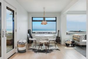 uma sala de jantar com mesa e cadeiras e o oceano em Luxury Modern Designer Beach House on Sand w/ Pool em Ventura