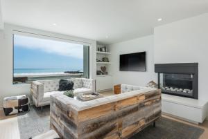 uma sala de estar com lareira e uma grande janela em Luxury Modern Designer Beach House on Sand w/ Pool em Ventura