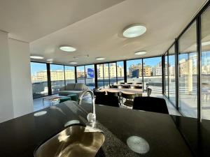 a kitchen with a sink and a large room with windows at Brand New apartment near port - piso 11 in Montevideo