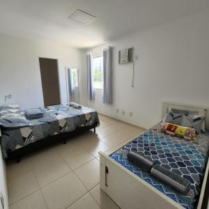 a bedroom with two beds and a window at Casa confortável pertinho da praia com garagem e quintal in Rio das Ostras