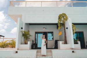 a woman in a white dress standing in front of a building at Bohol Coastal View Hotel in Tawala