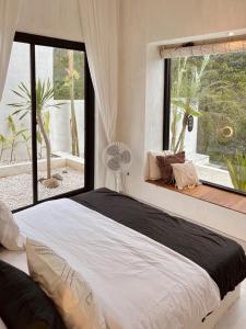 een slaapkamer met een groot bed en een groot raam bij Villa Soll A By The Villas 100 in Bogor