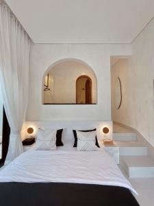 een slaapkamer met een wit bed en een spiegel bij Villa Soll A By The Villas 100 in Bogor
