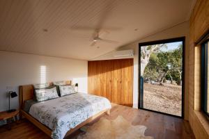 a bedroom with a bed and a large window at Luxury Ocean View house Saltbush Farm in Cape Jervis