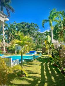 un complejo con una piscina con palmeras en PUNTA POPY Boutique HOTEL, en Las Terrenas