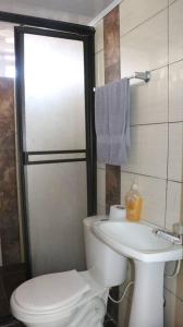 y baño con aseo y lavamanos. en Aparta Suite Torre De Prado Penthouse, en Medellín