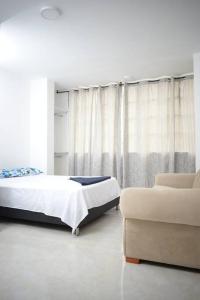 1 dormitorio con cama, sofá y ventana en casa nogal, en Medellín