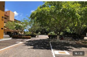 ein Baum auf einem Parkplatz neben einem Gebäude in der Unterkunft Resort flat Gavôa in Igarassu