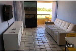 ein Wohnzimmer mit einem Sofa und einem Flachbild-TV in der Unterkunft Resort flat Gavôa in Igarassu