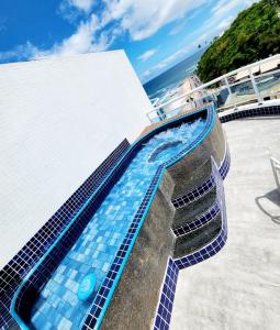 - une piscine avec des carreaux bleus sur le côté d'un bâtiment dans l'établissement Cobertura em Ondina, à Salvador