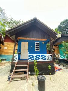 una casa azul con una escalera delante de ella en Bee Chalet Perhentian Island en Perhentian Island