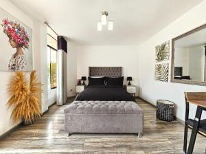 Un dormitorio con una cama y una otomana capitoné en Hospedaje Celerina & Elio, en Lima