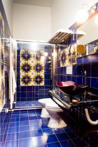 a blue tiled bathroom with a toilet and a sink at AM Collection Florence in Florence