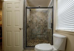 a bathroom with a shower with a toilet at Bear Paw Cabin new construction near Yosemite in Mariposa