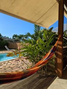 eine Hängematte auf einer Terrasse neben einem Pool in der Unterkunft Charmante villa créole climatisée, jardin tropical et piscine privés in Lamentin