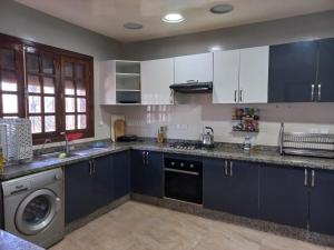 Bir Jedíd Saint-Hubert的住宿－Villa piscine bir jdid，厨房配有蓝色橱柜和洗碗机。