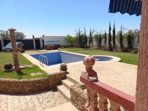 einen Hinterhof mit einem Pool und einem Zaun in der Unterkunft Villa piscine bir jdid in Bir Jedíd Saint-Hubert