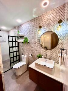 a bathroom with a sink and a toilet and a mirror at HOTEL Pinc in General Santos