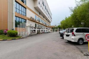 a parking lot in front of a large building at Selecta Hotel Medan Petisah R Signature Mitra RedDoorz in Medan