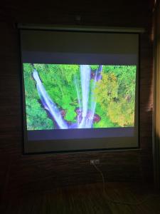 una TV con foto di una cascata di Tropical Bali Bamboo Villa - 7 Minutes from Canggu a Dalung