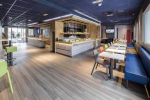 a restaurant with tables and chairs and a counter at Ibis Budget Valence Sud in Valence