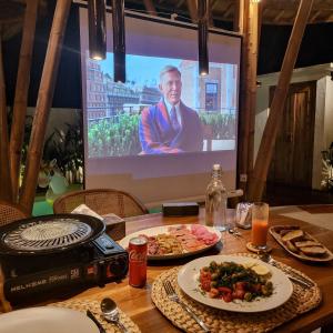 un tavolo con due piatti di cibo e un televisore di Tropical Bali Bamboo Villa - 7 Minutes from Canggu a Dalung