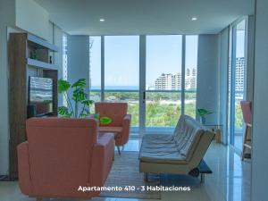 a living room with two chairs and a table at Apartamentos de lujo en Bello Horizonte in Santa Marta