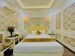 a bedroom with a king sized bed and a desk at Diamond Hotel Ha Noi in Hanoi
