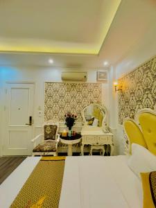 a living room with a chair and a piano at Diamond Hotel Ha Noi in Hanoi
