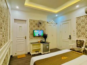 a bedroom with a bed and a tv on a wall at Diamond Hotel Ha Noi in Hanoi +19 photos