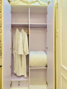 河内Diamond Hotel Ha Noi的配有白色衣服和床的衣柜