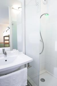 La salle de bains est pourvue d'un lavabo et d'une douche. dans l'établissement Ibis Budget Valence Sud, à Valence