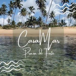 a view of a beach with palm trees and the ocean at Casa Mar in Praia do Forte