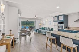 a kitchen and living room with a couch and a table at Sea La Vie in Airlie Beach