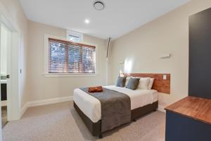 Un dormitorio con una cama grande y una ventana en Hardy Street School House en Nelson