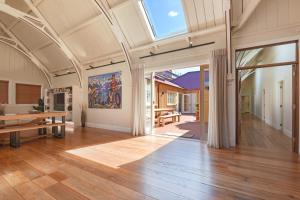 una grande camera con pavimento in legno e una grande finestra di Hardy Street School House a Nelson