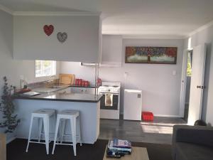 a kitchen with a counter and two stools in a room at My Place in Hokitika