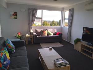 a living room with a couch and a tv at My Place in Hokitika