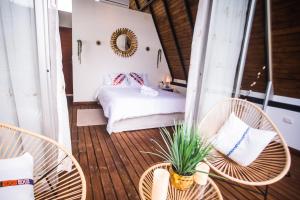 a bedroom with a bed and chairs and a table at Valhalla Nimaima Glamping in Nimaima
