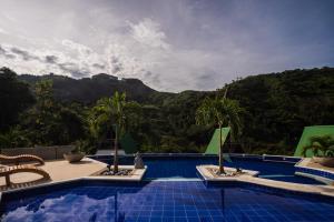 a swimming pool with a view of a mountain at Valhalla Nimaima Glamping in Nimaima