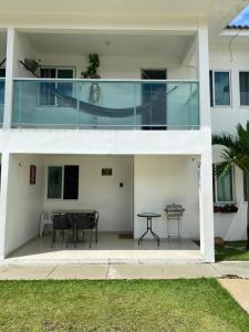 a large white house with a table on a patio at Excelente Bangalô/duplex em Jacumã - PB in Conde