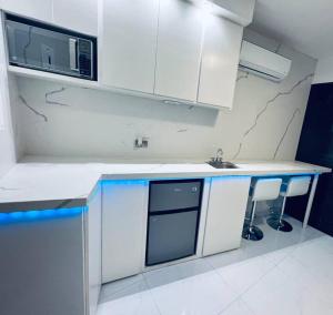 a white kitchen with a sink and a microwave at Departamento ejecutivo nuevo in Ciudad Obregón