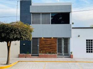 a building with a tree in front of it at Departamento ejecutivo nuevo in Ciudad Obregón