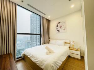 - une chambre avec un lit et une grande fenêtre dans l'établissement VNRooms - 2BR Vinhomes Skylake Apt Full Service, à Hanoï