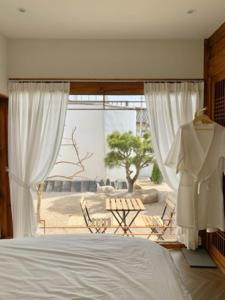 ein Schlafzimmer mit einem Bett und einem großen Fenster in der Unterkunft EL House in Gyeongju