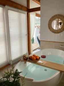 a bath tub with a bowl of oranges and a glass of wine at EL House in Gyeongju